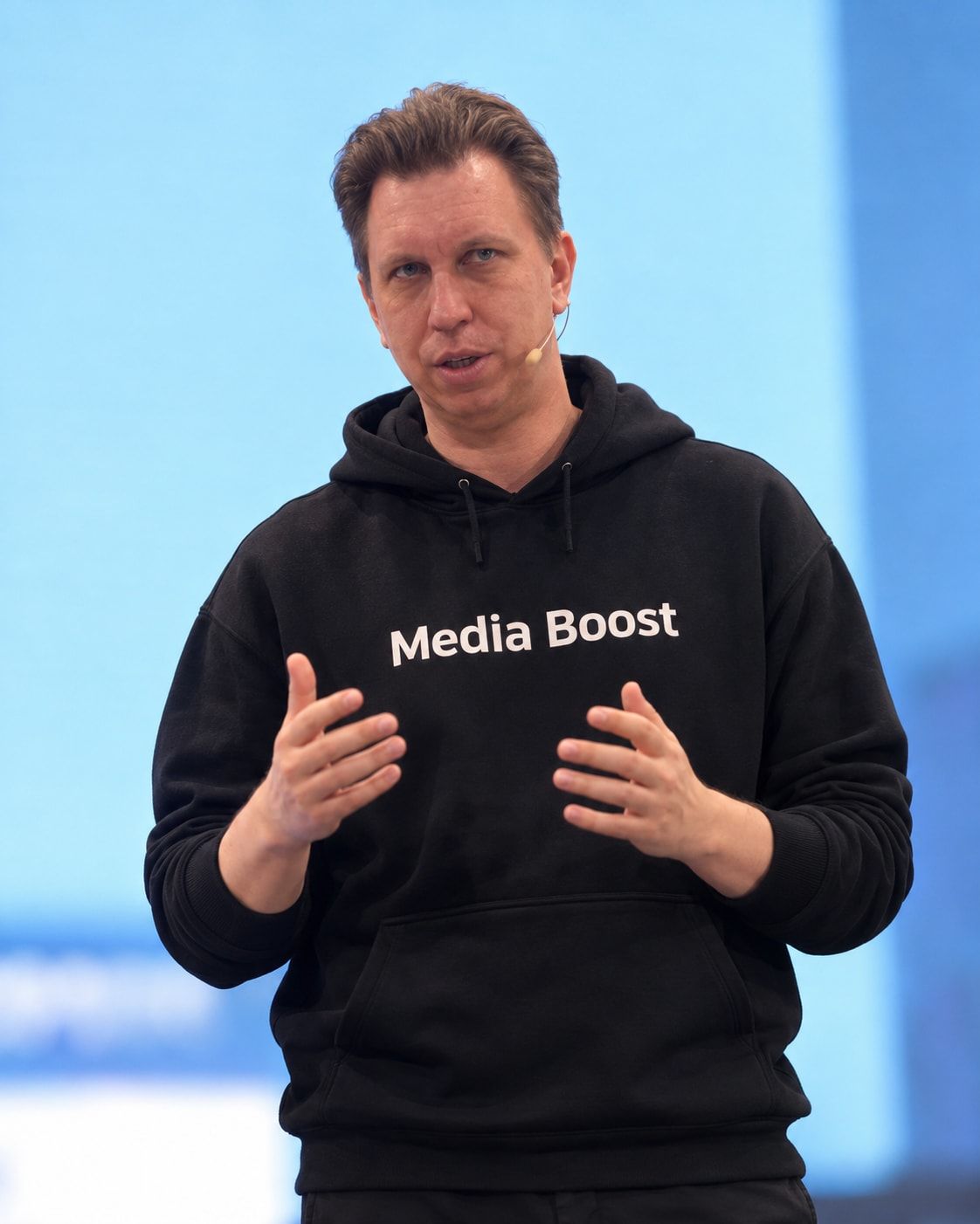 Сергей Ахметов выступает на сцене в худи с надписью Media Boost